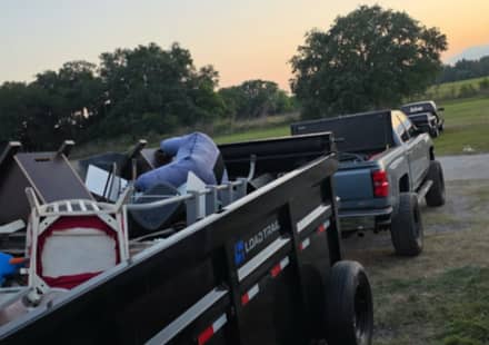 A loaded RHR dump trailer hitched to the truck at sunset after a clear-out