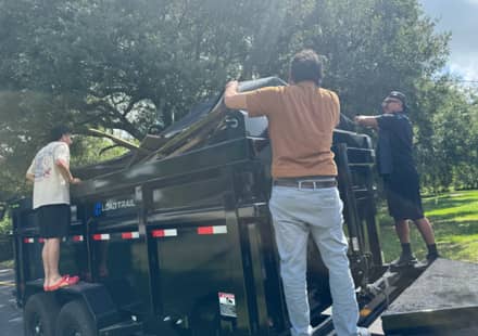 Two of the RHR crew lifting a mattress into the trailer